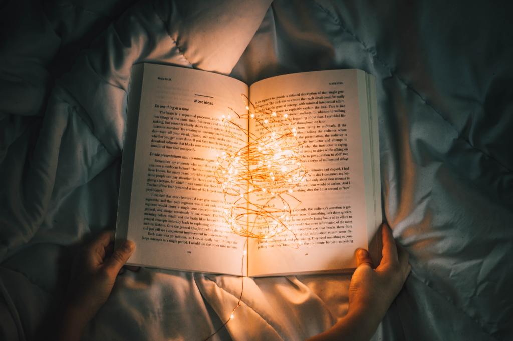 photo of an open book illuminated by string lights